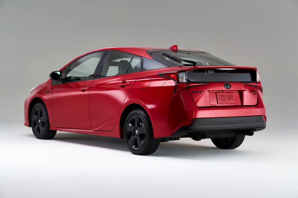 Driver's side rear angle view of red 2022 Toyota Prius