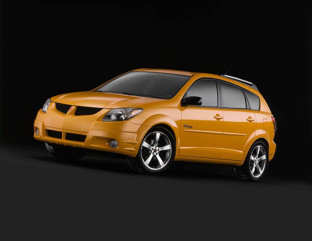 orange Pontiac Vibe against a black background. This is one of the best affordable cars you can buy under $5,000 