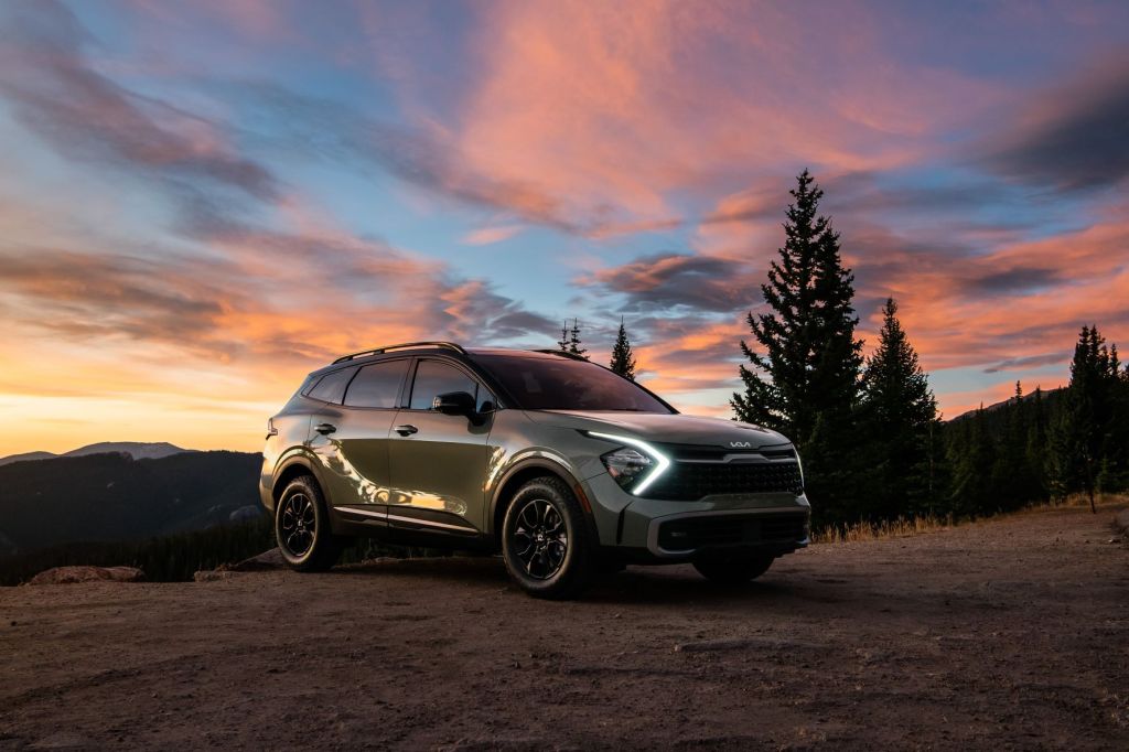 Green 2023 Kia Sportage with a sunset in the background