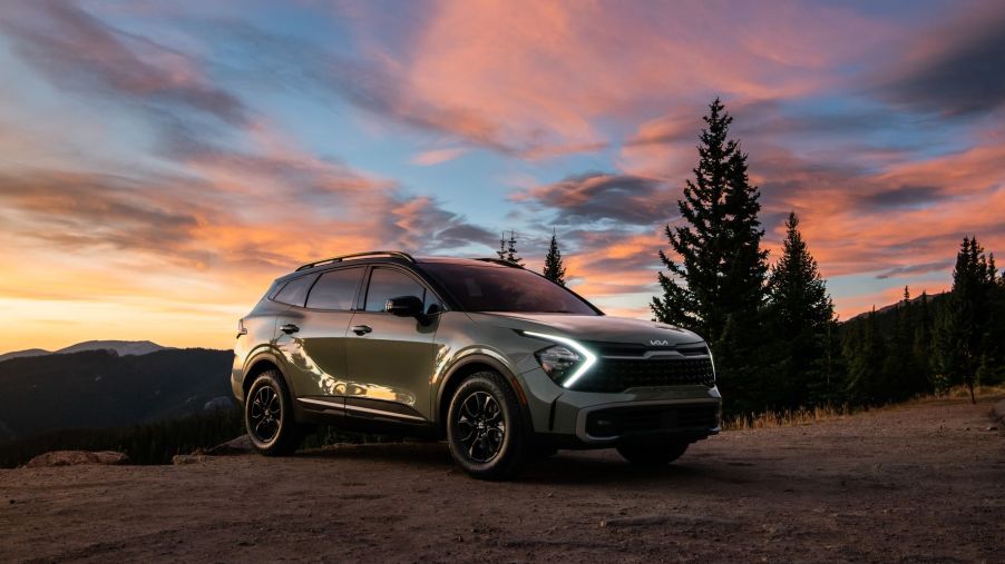 Green 2023 Kia Sportage with a sunset in the background