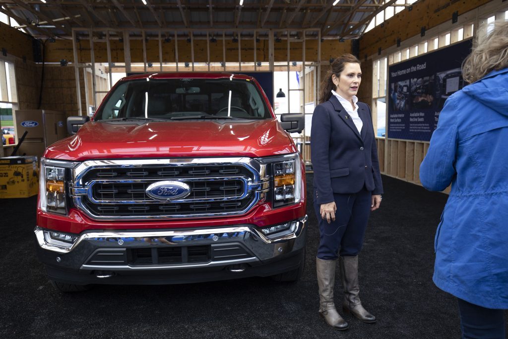 Michigan Governor Gretchen Whitemer standing in front of a Ford Pickup truck. 