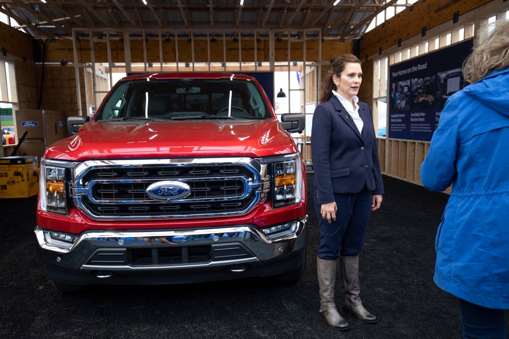 Michigan Governor Gretchen Whitemer standing in front of a Ford Pickup truck.
