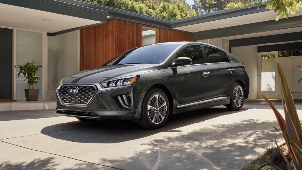 Grey 2022 Hyundai Ioniq Plug-In Hybrid, a PHEV to save money on gas, parked next to a house