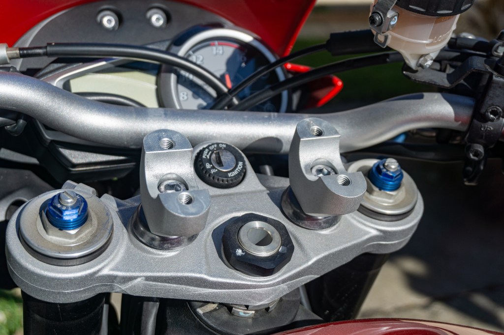 A red 2012 Triumph Street Triple R's handlebar mounts shown with the handlebar removed