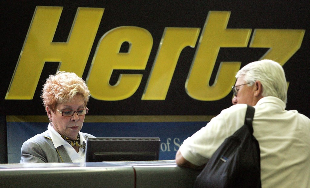 A Hertz worker assists a customer at its rental-car pickup area on July 17, 2006, at O'Hare International Airport in Chicago, Illinois.
