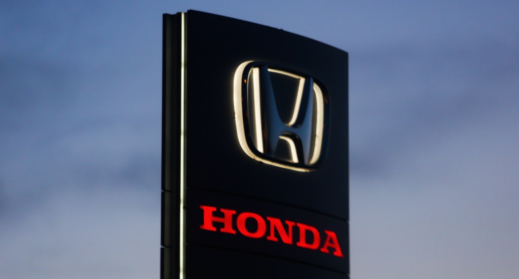 A black sign with a Honda logo. 