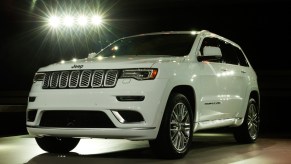 A white Jeep Grand Cherokee is on display.