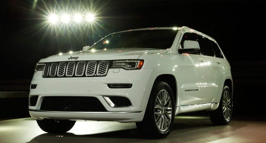 A white Jeep Grand Cherokee is on display.