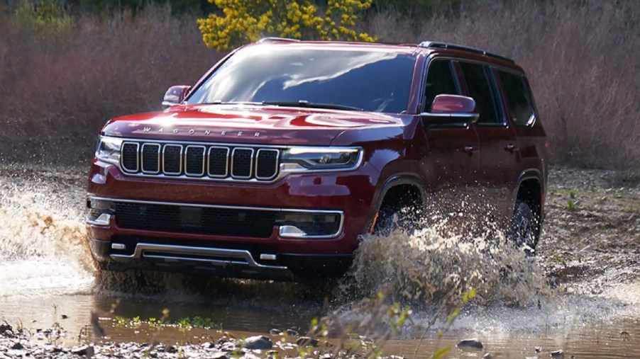 A red 2022 Jeep Wagoneer is driving through deep water.