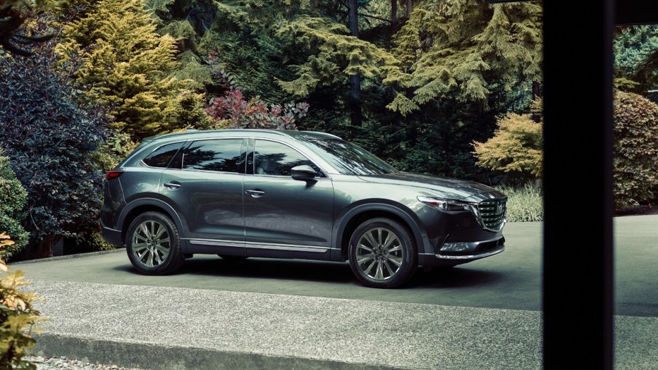 A silver 2021 Mazda CX-9 parked in front of woods.