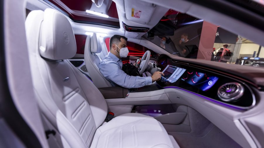 A man interacts with the infotainment on a Mercedes-Benz EQS EV sedan