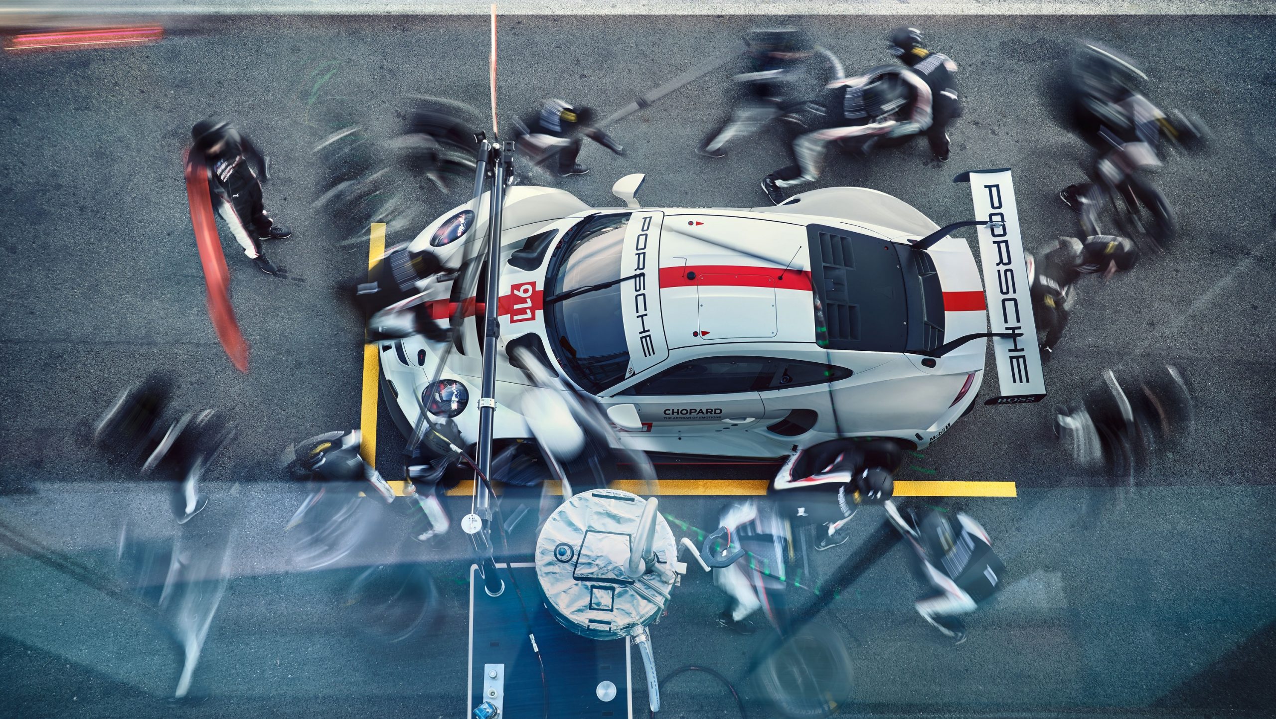 A white Porsche 911 RSR race car during a pit stop