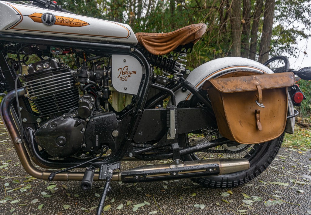 A side view of a pre-production 2021 Janus Halcyon 450's engine and frame in a forest