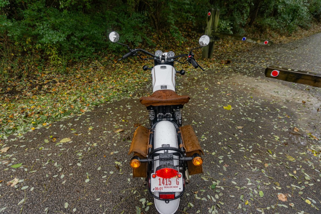 An overhead rear view of a white-and-gold pre-production 2021 Janus Halcyon 450 on a forest path