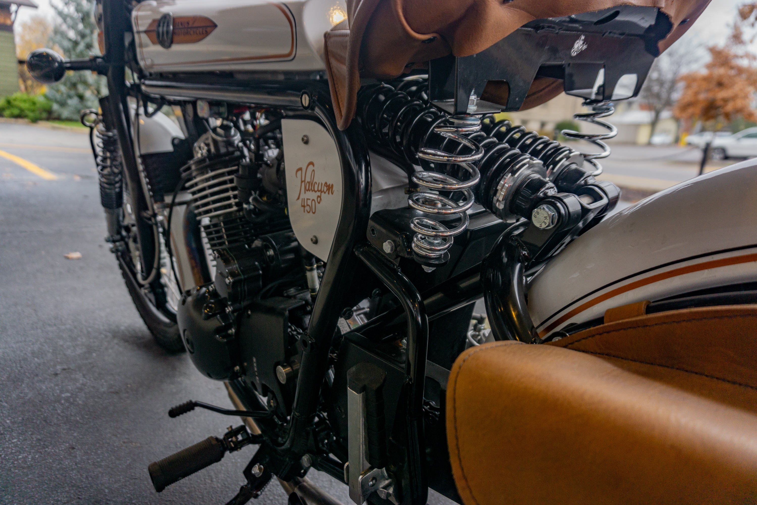 A close-up view of a white-and-gold pre-production 2021 Janus Halcyon 450's rear suspension