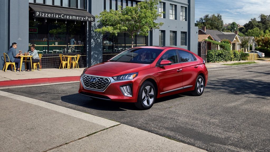 Red 2022 Hyundai Ioniq Hybrid, a good non-electric car to save money on gas, parked on a city street
