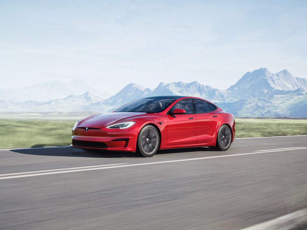 Red 2022 Tesla Model S driving on a curvy road