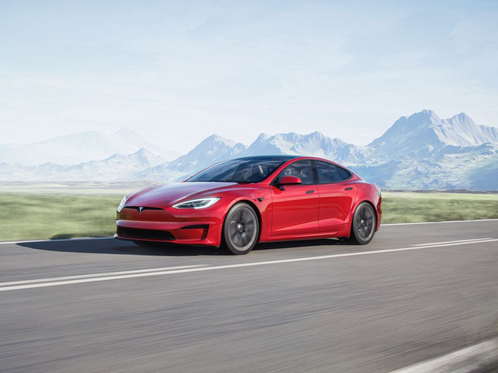 Red 2022 Tesla Model S driving on a curvy road