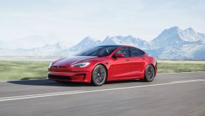 A fully loaded red 2022 Tesla Model S driving on a curvy road