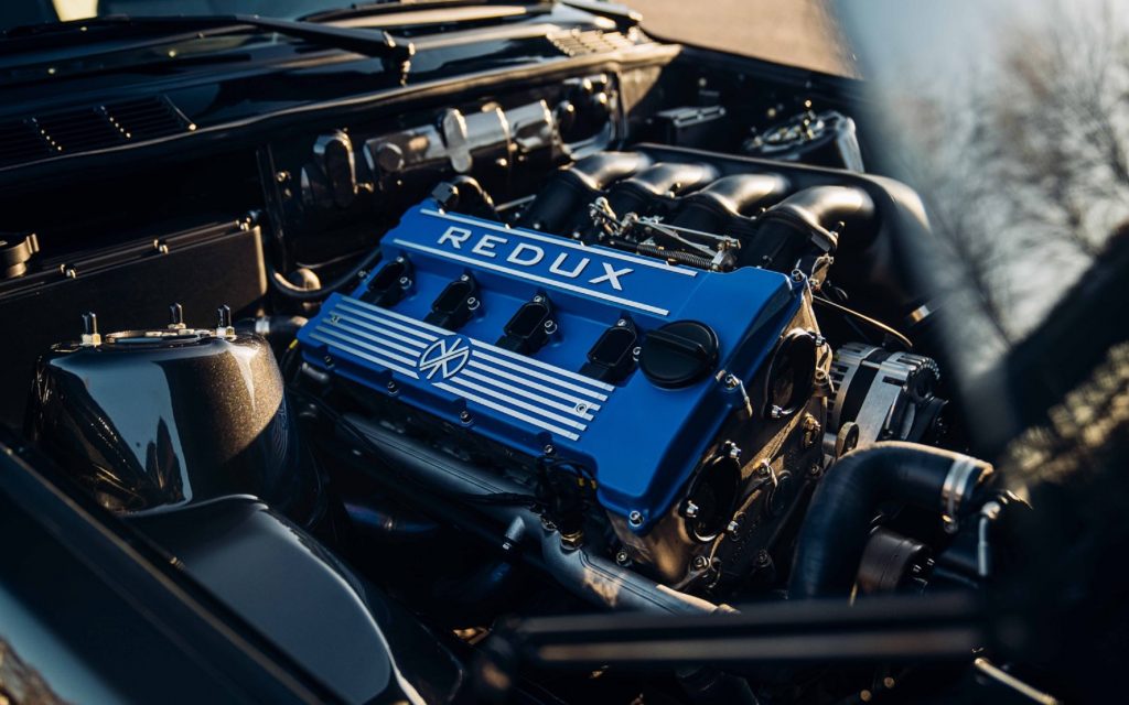 The blue-covered S14B25 engine in a black Redux Enhanced & Evolved BMW E30 M3