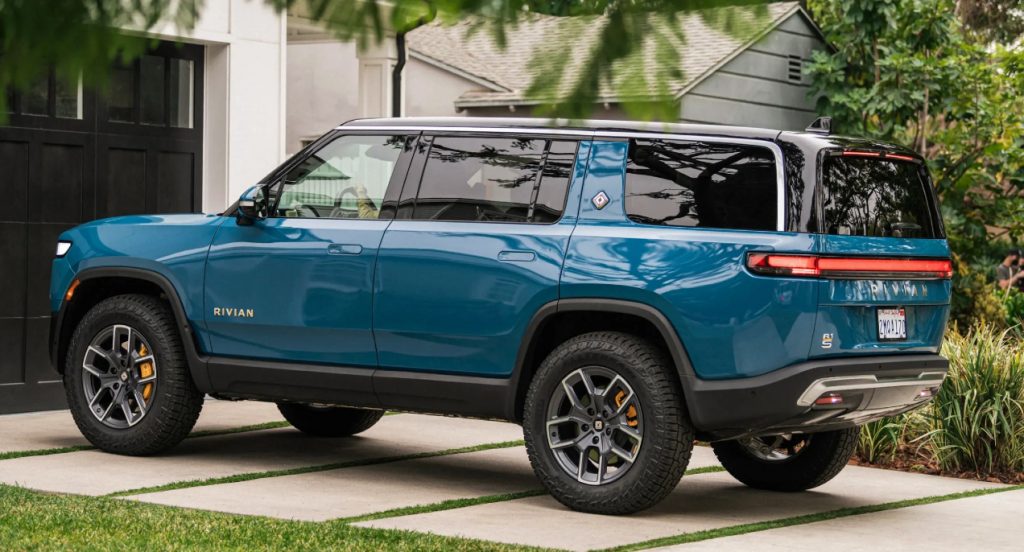A blue 2022 Rivian R1S electric SUV is parked in a driveway.