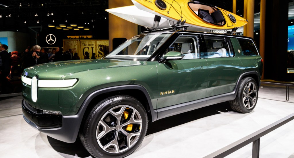 A green Rivian R1S electric SUV is on display.