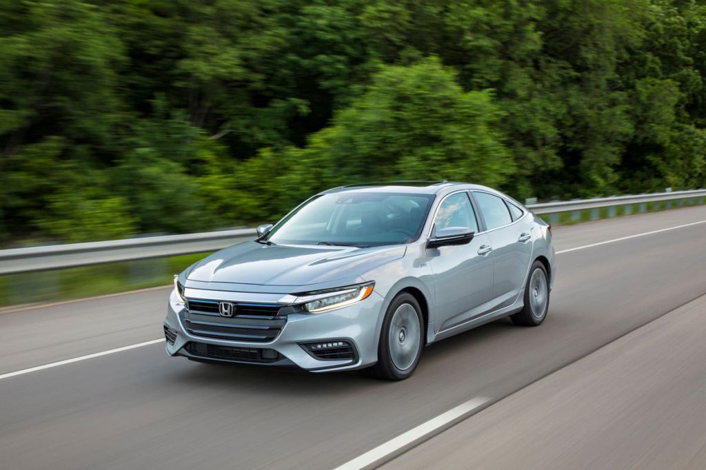 Silver 2022 Honda Insight, a good non-electric car to save money on gas, driving by a forest
