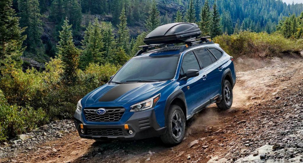 A blue 2022 Subaru Outback Wilderness is driving off-road. 