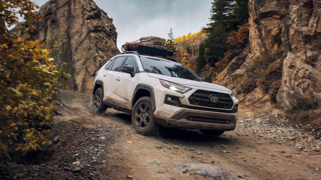 Super White 2022 Toyota RAV4 driving off-road on a rocky path