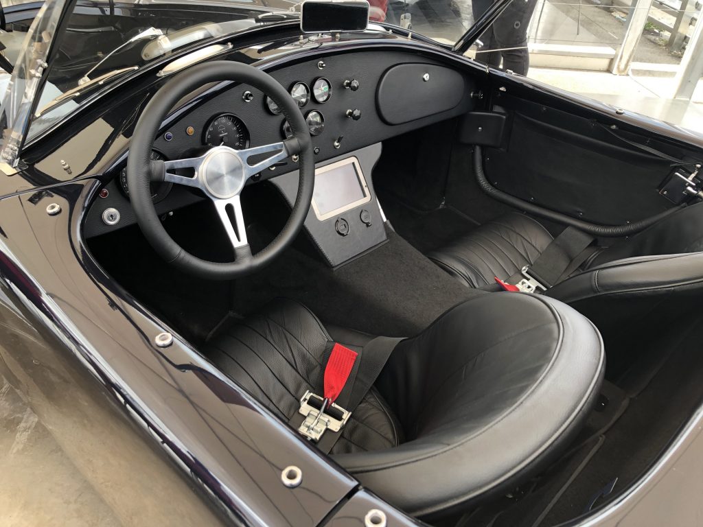 The black-leather seats and black dashboard of the Superformance MKIII-E electric Shelby Cobra replica prototype