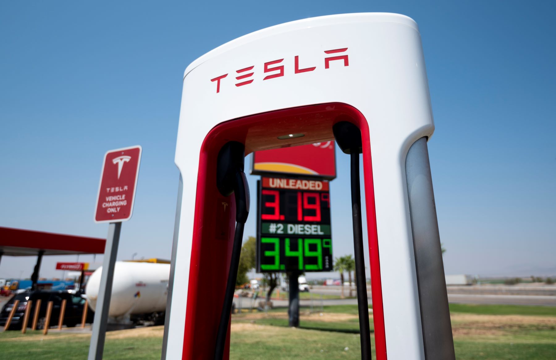 A Tesla charging station in front of a gas station in Ehrenberg, Arizona