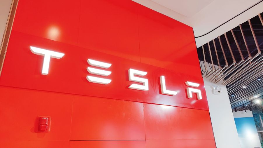 Red Telsa sign with Tesla written in white.
