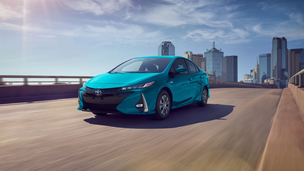 Turquoise 2022 Toyota Prius Prime, a PHEV to save money on gas, driving in a city