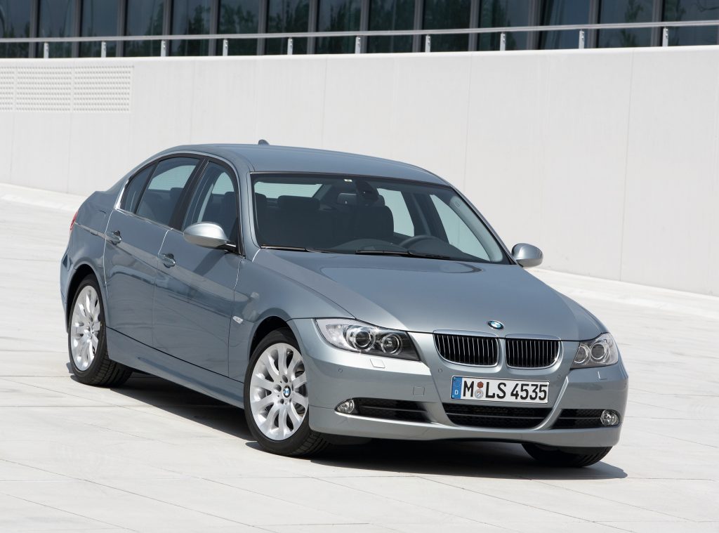 A silver used 2008 BMW E90 328i on a curving road