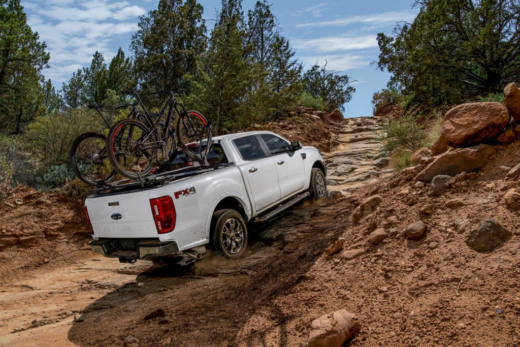 White 2022 Ford Ranger driving up a rocky hill, with a Consumer Reports reliability rating of 4 out of 5