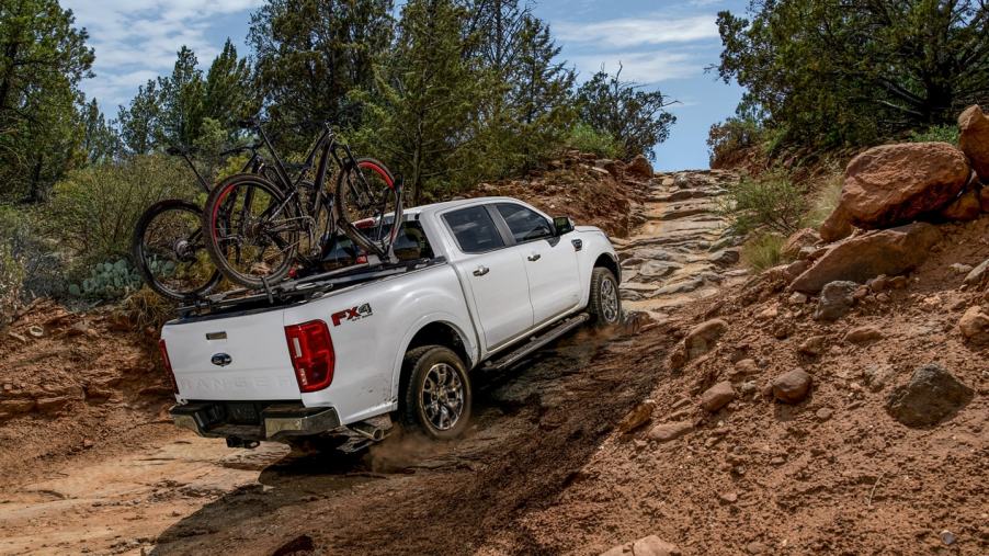 White 2022 Ford Ranger driving up a rocky hill, with a Consumer Reports reliability rating of 4 out of 5