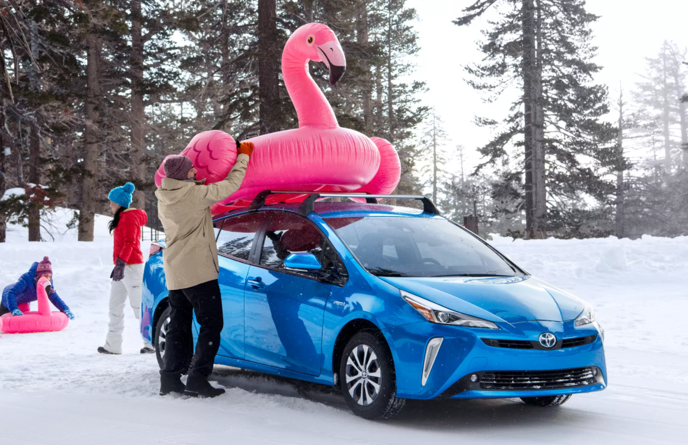 Woman placing a pink inflatable on a 2022 Toyota Prius