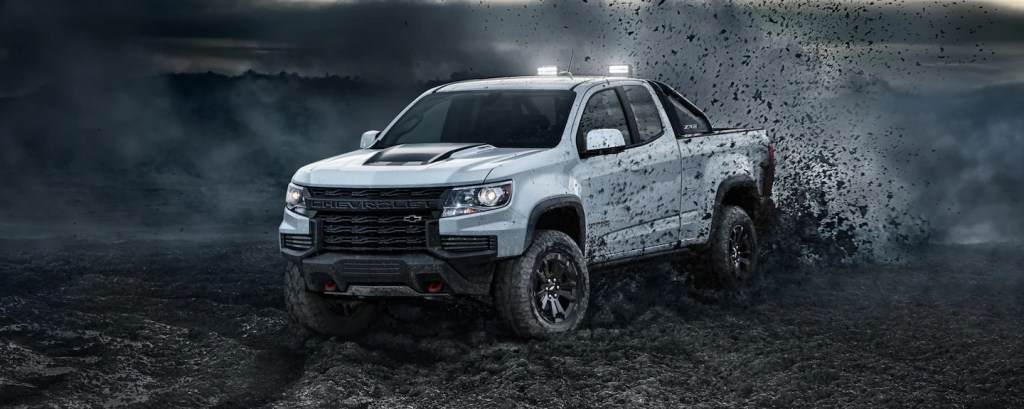 A white 2022 Chevy Coloardo off-roading in dirt and rocks.