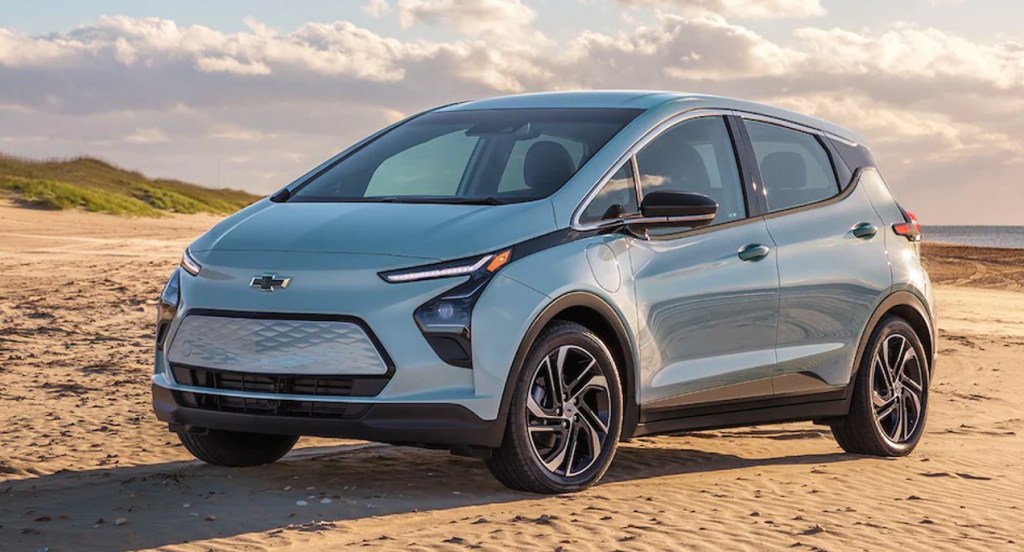 A silver 2022 Chevy Bolt is parked on the sand. 