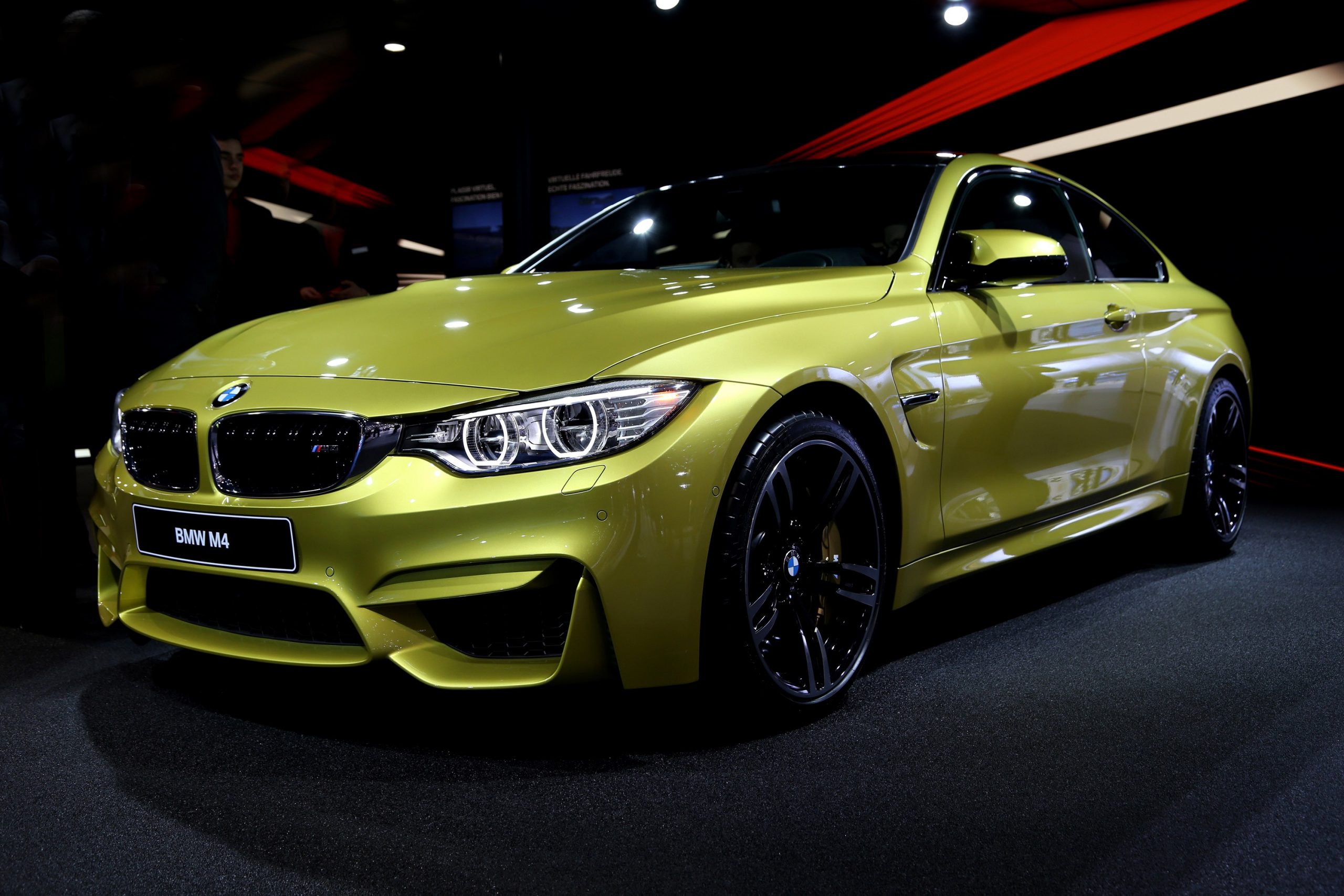 A Phoenix Yellow F80 generation M4 at an auto show
