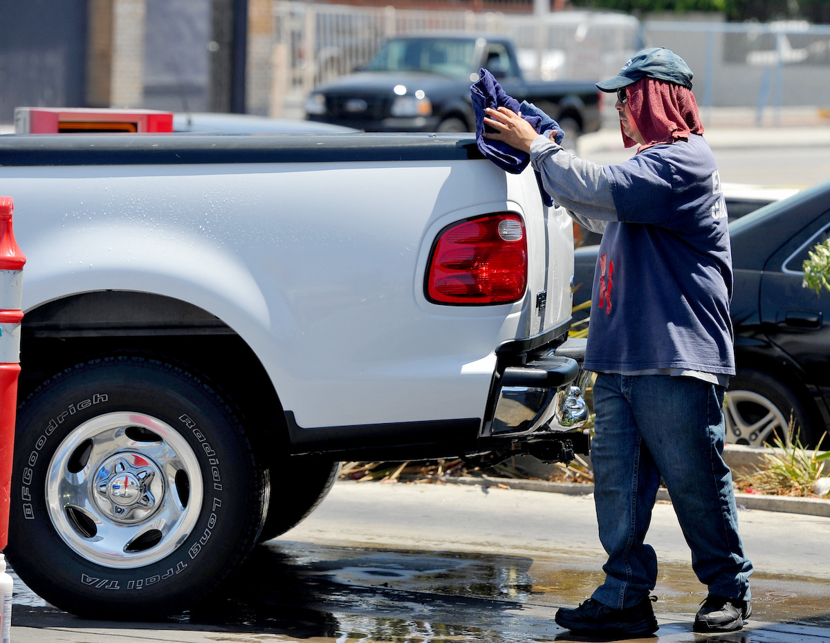 A worker at a car wash dries a truck with a tow hitch in Long Beach, California, in July 2014
