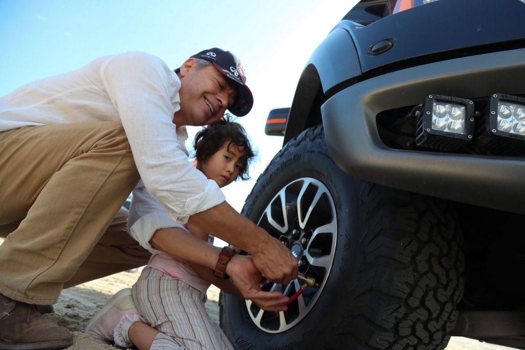 A man checks the tire pressure on a tire
