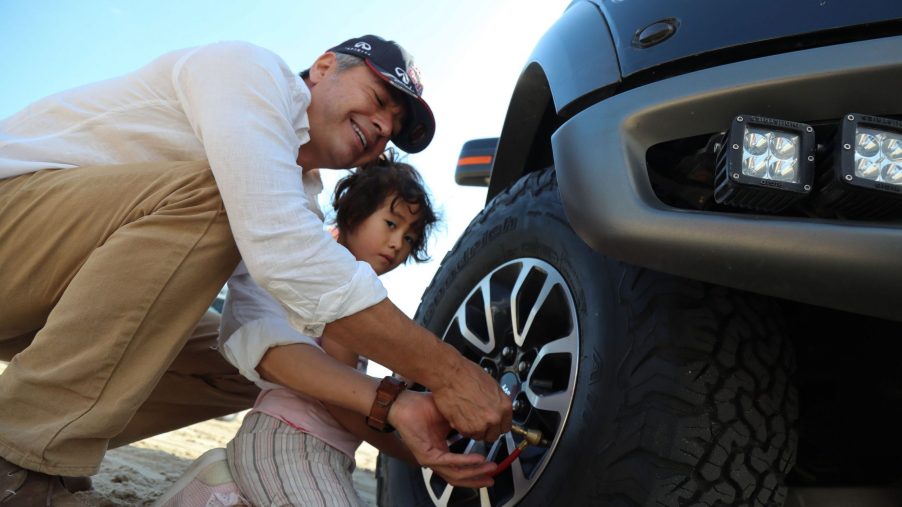 A man checks the tire pressure on a tire