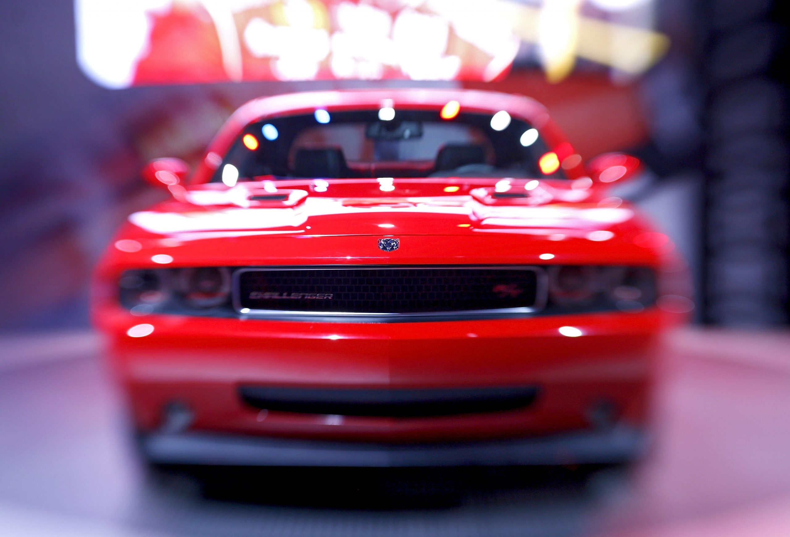 A red Dodge Challenger shot from the front at an auto show
