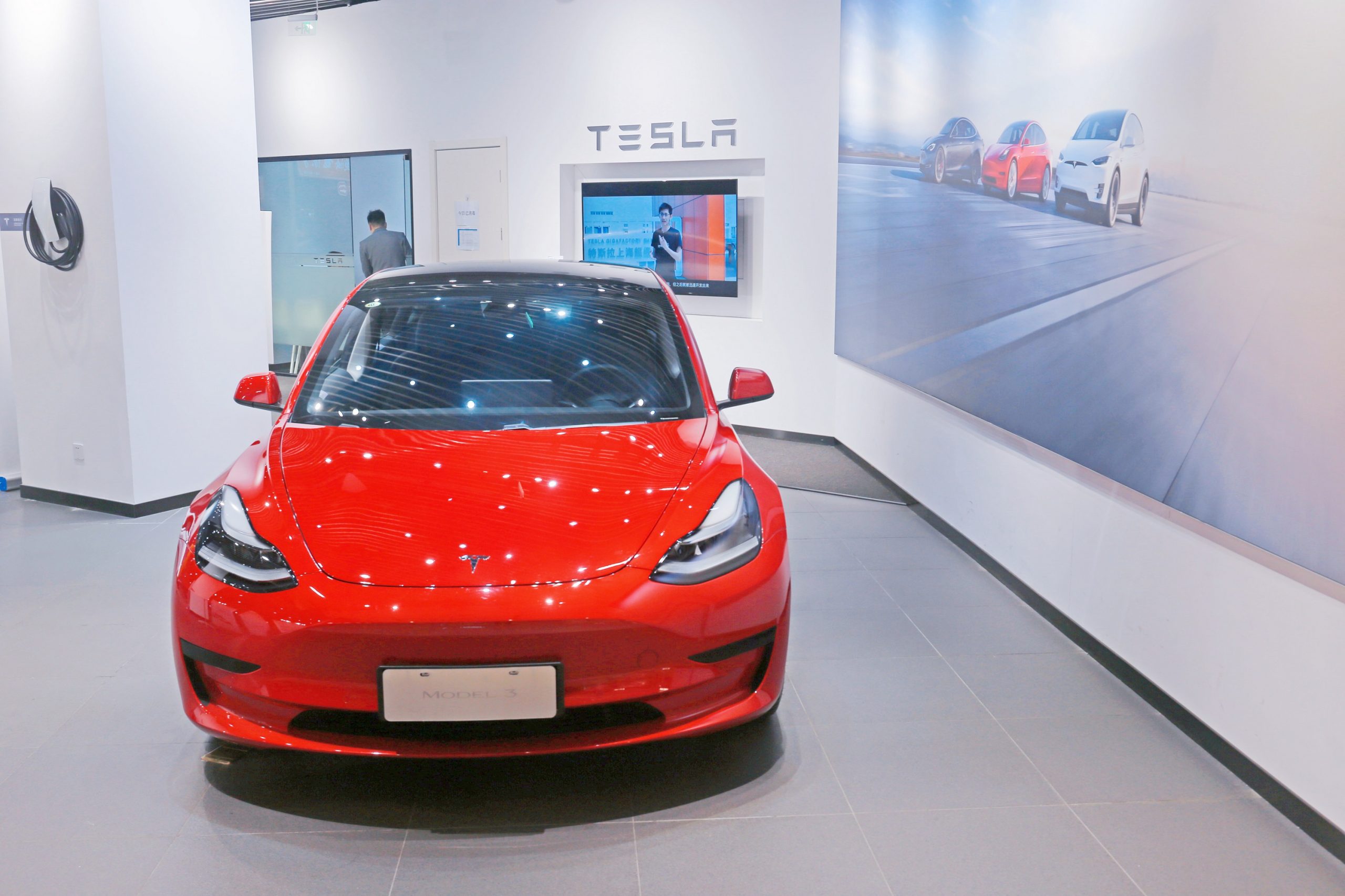 A red Tesla Model 3 EV in a dealership