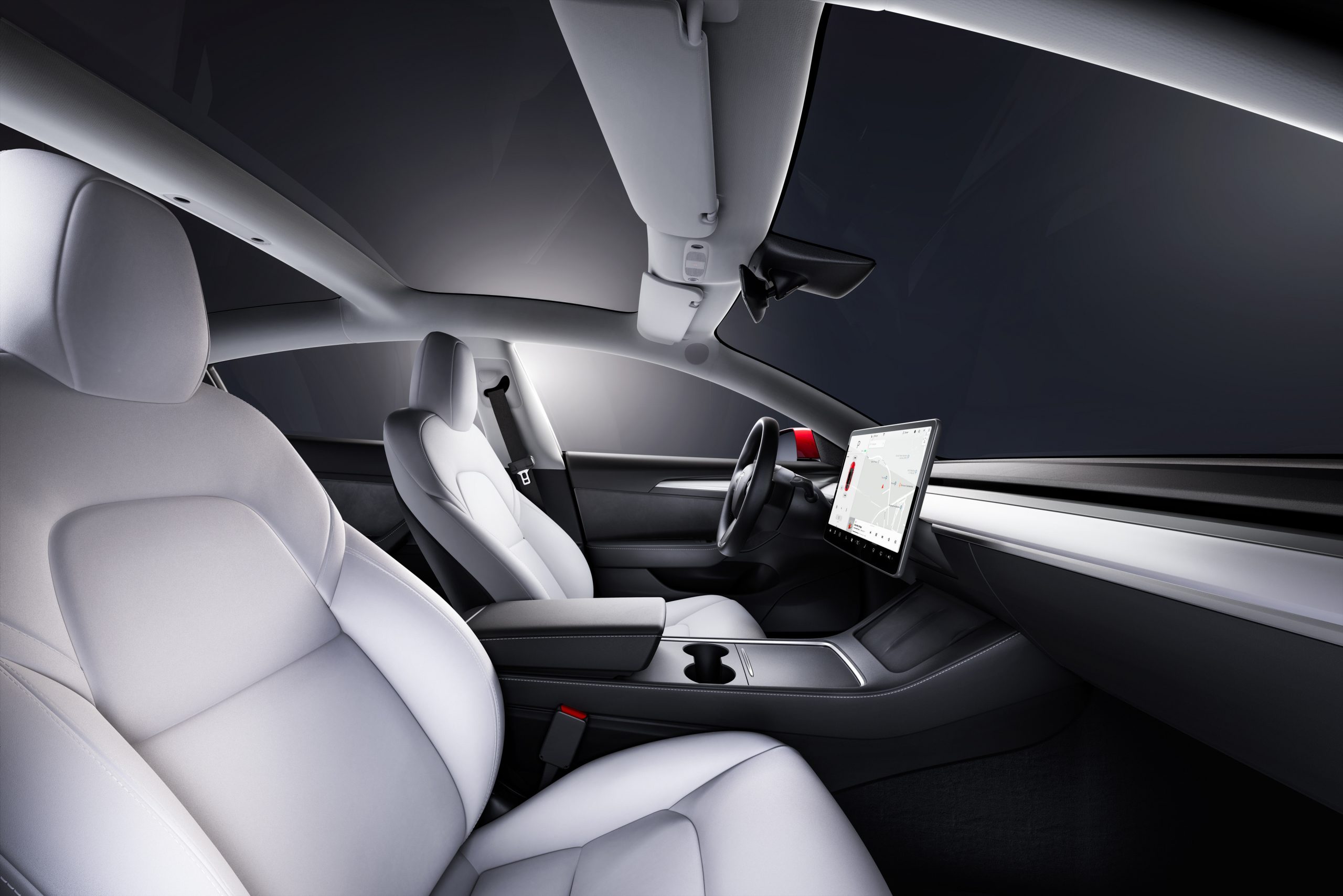The white interior of a Tesla model 3 shot from the passenger seat