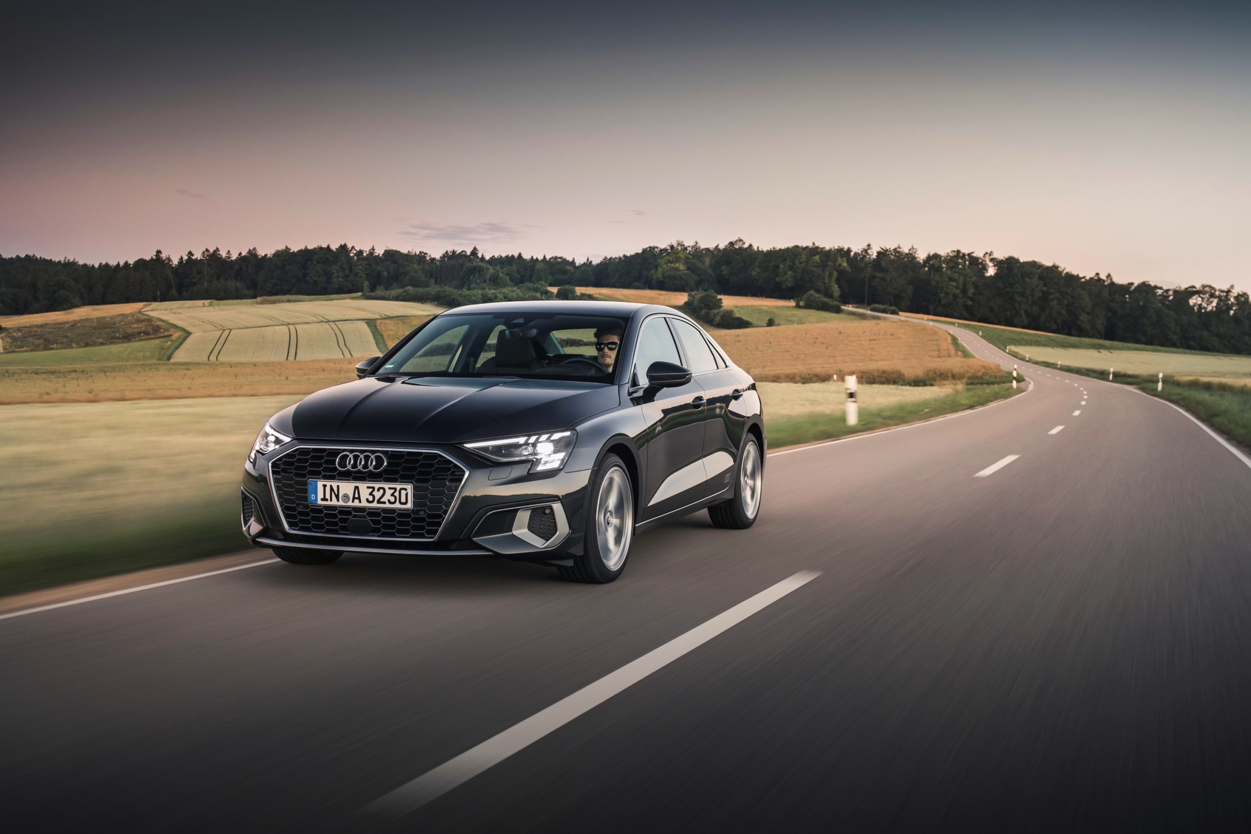 A grey 2022 Audi A3 shot from the front 3/4 on a country road
