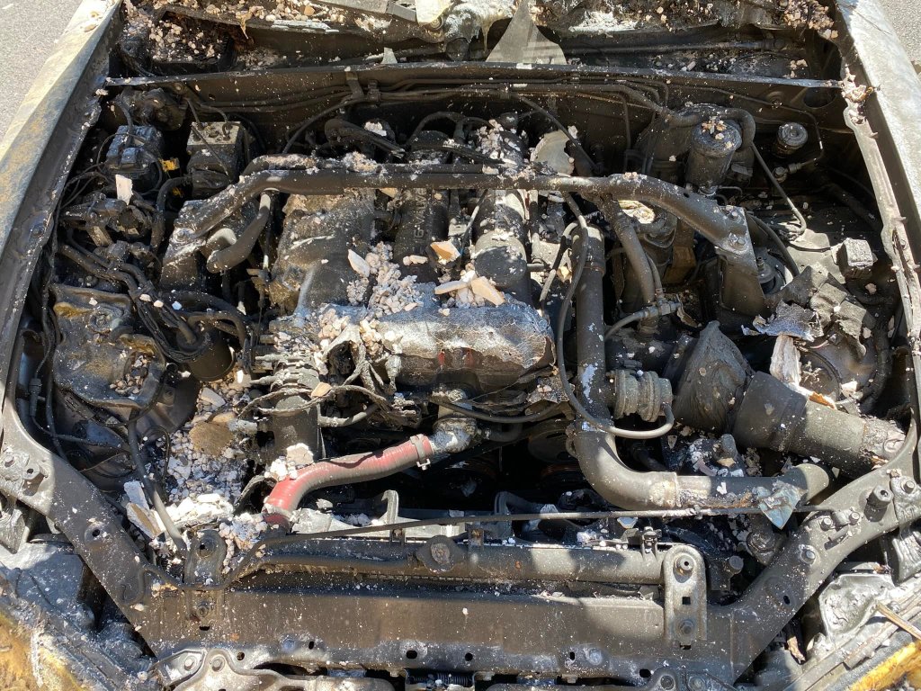 The engine bay of the burnt-up Mazdaspeed Miata