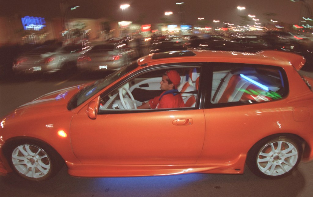 18-year-old Faraz Matin drives his modified 1993 Honda Civic through a parking lot.