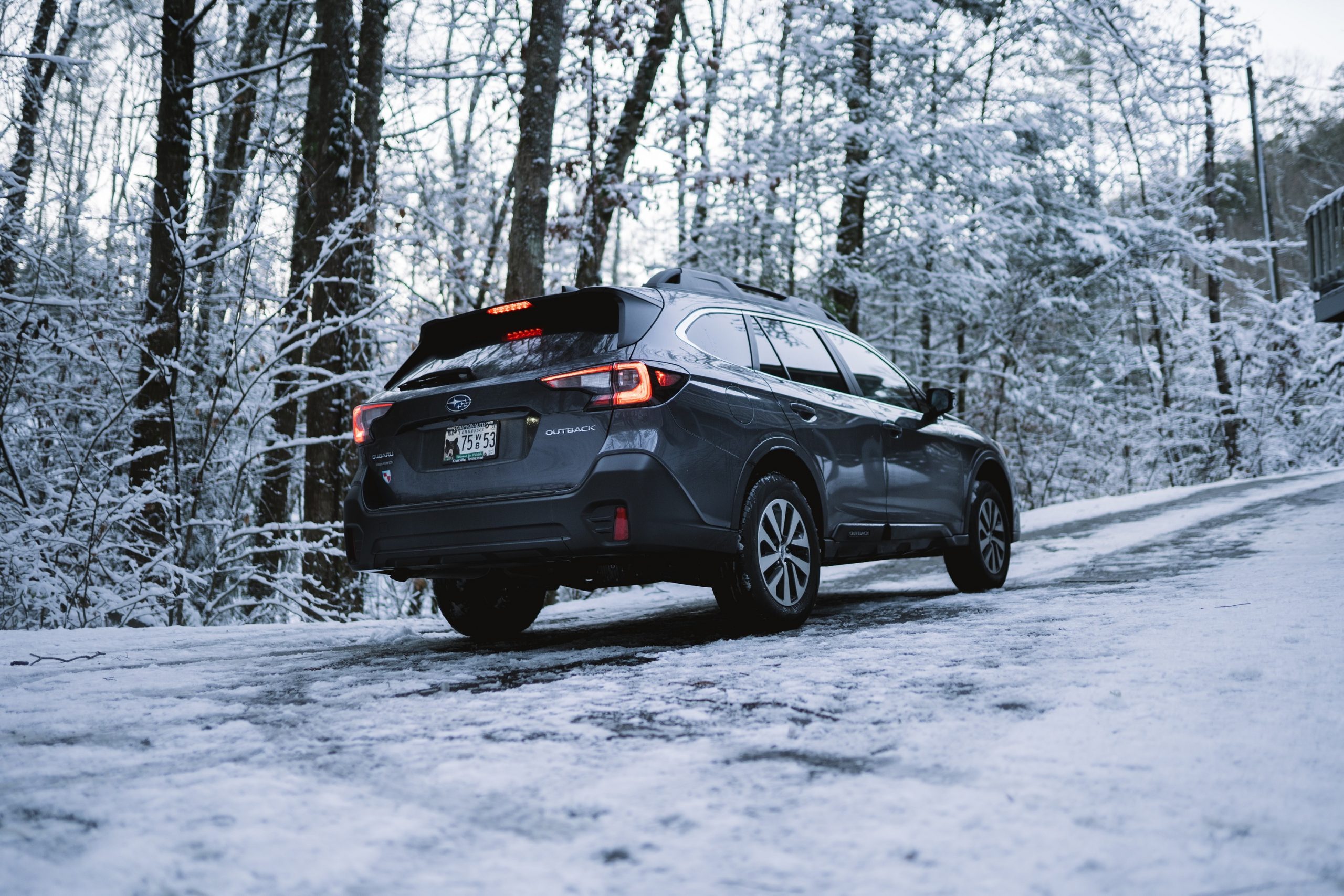 A Subaru Outback wagon shot from the rear on a snowy trail